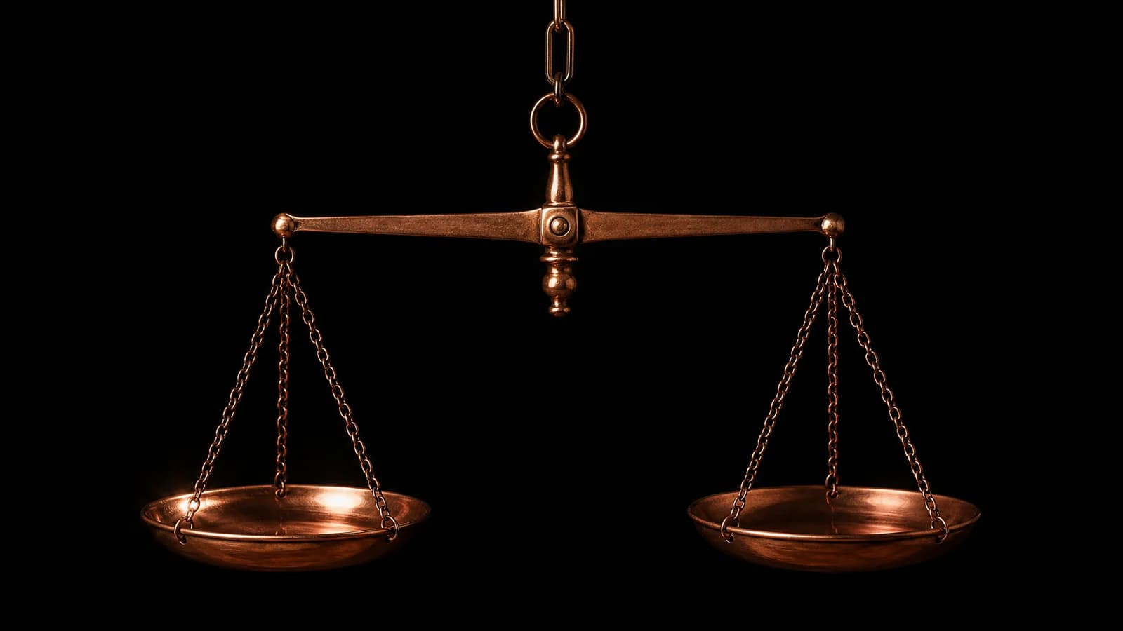 A copper balance scale in equilibrium on black